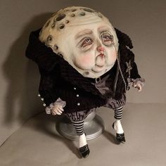 a creepy doll sitting on top of a metal base