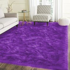 a living room with a white couch and purple rug