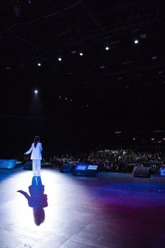 a man standing on top of a stage in front of an audience at a convention