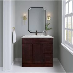 a bathroom with a sink, mirror and lights on the side of the wall above it