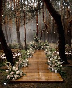 an outdoor ceremony setup with candles and flowers on the floor, surrounded by trees in the background