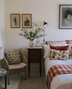 a bedroom with white walls and pictures on the wall