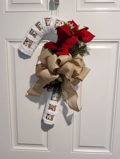 a door hanger decorated with red roses and burlocks for the holiday season