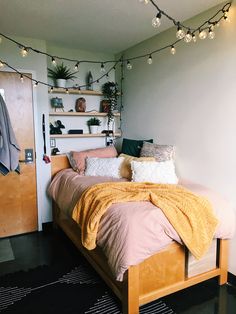 a bed sitting in a bedroom next to a wooden door with string lights on it