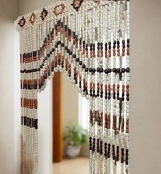 a beaded curtain hanging from the side of a wall in front of a mirror