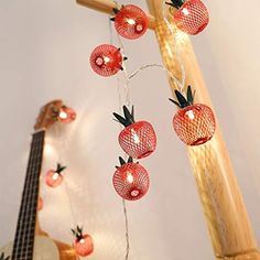 string lights with pineapples on them hanging from a wooden pole next to a bass