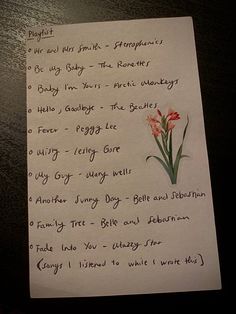 a piece of paper with writing on it and flowers in the corner next to it