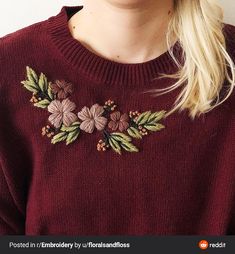 a woman wearing a red sweater with flowers on it