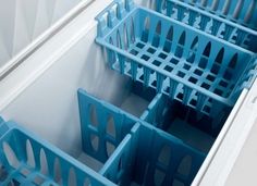 several blue plastic containers are stacked in a drawer