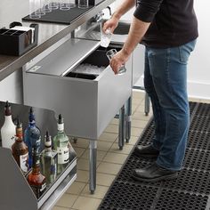 a man standing in front of a counter filled with bottles