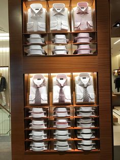 there are many shirts and ties on display