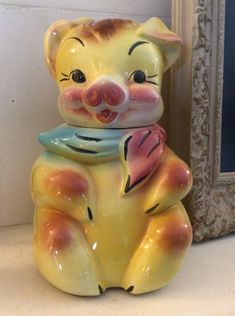 a yellow and orange cat figurine sitting next to a mirror