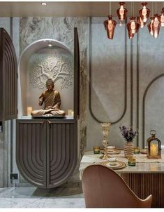 a buddha statue sitting on top of a counter next to a table with candles and vases