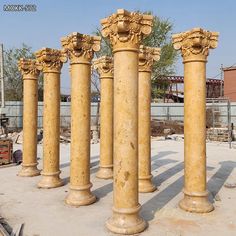 four stone pillars in the middle of a construction site