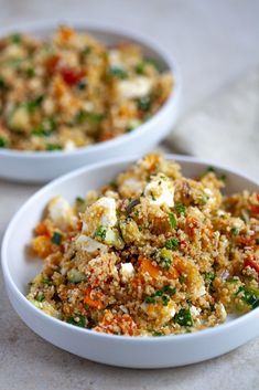 two white bowls filled with food on top of a table