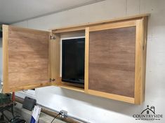 an open cabinet with a tv mounted to it's side in a room under construction