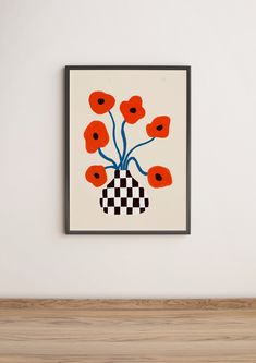 an art piece with red flowers in a black and white vase on a wall above a wooden shelf