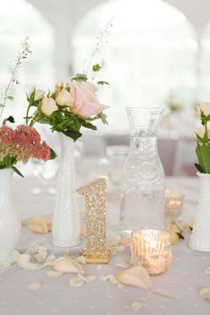 vases filled with flowers on top of a table covered in confetti and petals