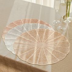 three placemats sitting on top of a table next to wine glasses and flowers