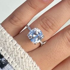 a woman's hand with a ring on it and a blue diamond in the middle