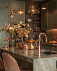 a kitchen with marble counter tops and an island in the middle, surrounded by green cabinets