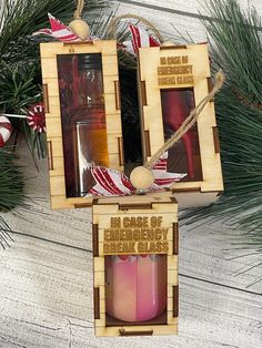 two wooden boxes with candles in them sitting next to pine branches and christmas decorations on the table