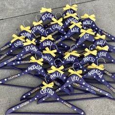 a bunch of blue and yellow clothes hangers with name tags attached to them on the sidewalk