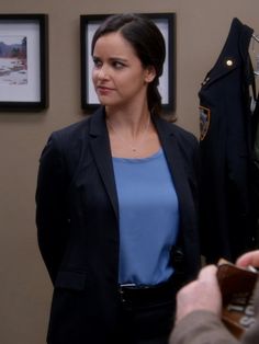 a woman is looking at her cell phone while standing in front of a police uniform