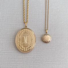 An adult-size 14K yellow gold-filled engraved floral signet oval locket on a rope chain necklace. The outer shell is solid gold pressure-bonded to an inner core of high-quality brass. Locket Dimensions: 30 mm W x 38 mm H Chain length: 22" Classic Oval Locket Necklace Stamped 14k, Yellow Gold Oval Pendant Locket Necklace, Oval Etched Brass Jewelry, Heirloom Oval Etched Necklace, Gold Oval Jewelry With Vintage Charm, Classic Gold Oval Locket Necklace, Classic Oval Locket Necklace With Vintage Charm, Gold Classic Locket Necklace With Engraving Option, Gold Oval Heirloom Locket Necklace