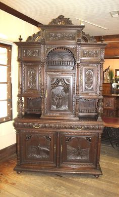 an ornate wooden cabinet in the middle of a room