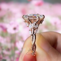 a close up of a person's hand holding an engagement ring