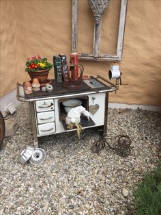 an old fashioned stove with pots and pans on it in front of a house