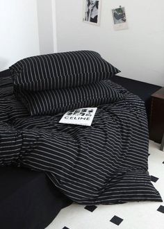 a black and white bed with two pillows on top of it next to a night stand