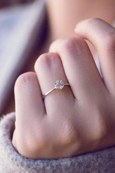 a woman's hand with a diamond ring on it