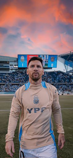 a man standing on top of a soccer field in front of a sky filled with clouds