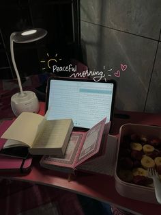 an open laptop computer sitting on top of a desk next to a bowl of fruit