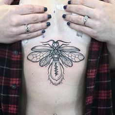 a woman's chest with a bee tattoo on it