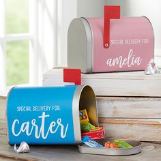 two mail boxes with candy in them on a table