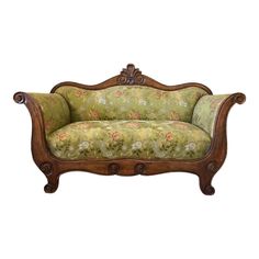 an old fashioned couch with floral fabric on it's back and arms, sitting in front of a white background