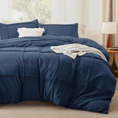 a blue comforter set with white pillows