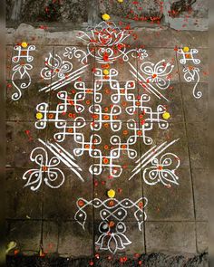 an intricately designed design on the ground in white and orange colors with red dots