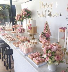 a table topped with lots of cakes and cupcakes on top of it's sides