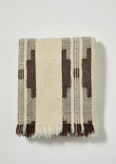 a brown and white checkered blanket with tassels on the ends, hanging from a wall