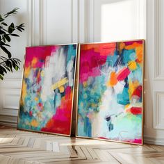 two abstract paintings on the wall next to a potted plant in an empty room