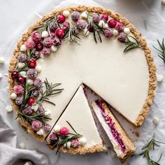 a cheesecake with cranberry sauce and sprinkles is shown on a white surface