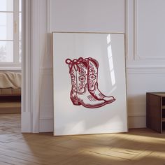 a pair of cowboy boots are on display in a room with white walls and wooden floors