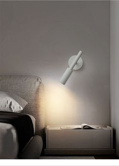 a bed with a lamp on top of it next to a book