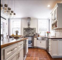 a kitchen with white cabinets and red tile flooring is featured in this article for the love of homes