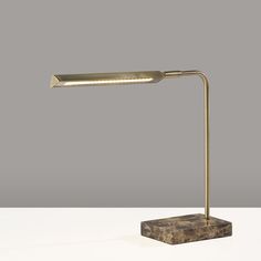 a desk lamp with a marble base and metal arm