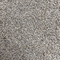 the texture of an area rug is shown in grey and white colors, with small speckles on it